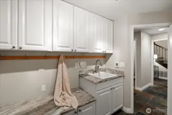 The mudroom is a perfect place to drop your shoes and backpacks, keep pet supplies, extra storage and to wash up after working in the garage. This space was previously the main floor laundry and the water lines are still in the wall should you want to move the laundry back downstairs. This space features the same resilient dolomite countertop material as in the kitchen.