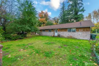 Front lawn and private entrance for Unit Two with wide windows for natural light. Established trees frame the property, offering shade and separation from neighboring homes.