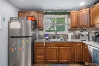 Unit 2 - Sink & Window View  Large kitchen window allows natural light to pour in while offering pleasant backyard views. Double-basin sink, updated fixtures, and generous counter space support everyday functionality.