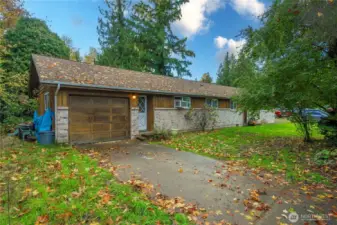 Unit 1 Entrance & Garage - Single-level duplex with a classic brick façade, attached one-car garage for Unit One, and easy driveway parking. Mature landscaping and a quiet cul-de-sac setting add privacy and curb appeal.