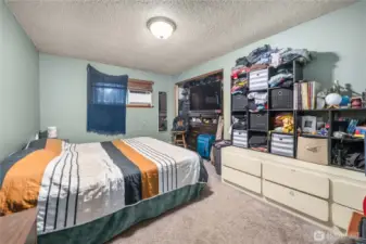 Unit 1 Generous primary bedroom with wall-to-wall carpeting, overhead lighting, and a wide closet opening that provides substantial storage and organization options.