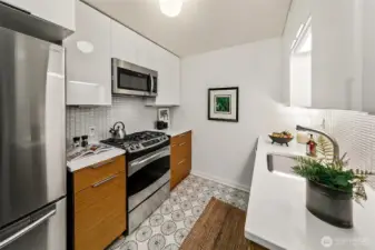 The kitchen has newer appliances and tile flooring.