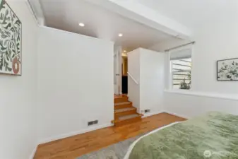 Spacious primary suite. Steps go up to ensuite and walk-in closet.