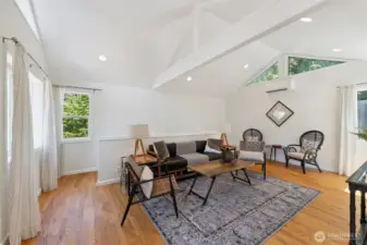 Spacious family room located in the back of the home. Staircase beyond the half wall provides access to basement.