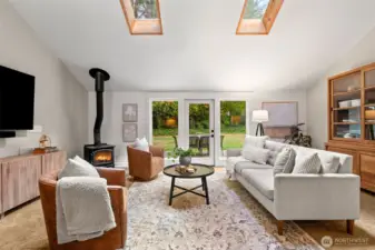 The main living room is light and bright with two large skylights and oversized windows on either side of the French doors leading out to the patio.