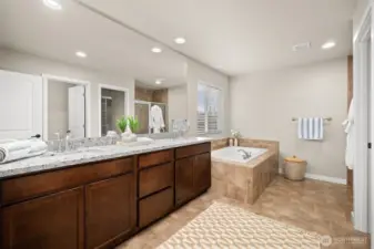 Primary en-suite with double vanity and soaking tub.