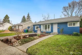 Thoughtful landscaping frames the home, from the rain-wise front garden to the mature plantings throughout the lot.