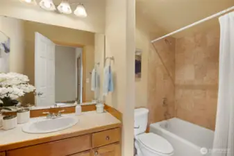 This full bathroom is attached to the primary bedroom.  The tile surround and the right-sized vanity make it the perfect spot to start your day.