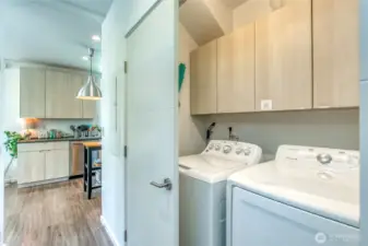 A full-sized washer and dryer are discreetly located at the base of the stairwell.