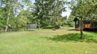 Level backyard with a lovely grassy lawn.