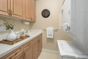 Utility room offers plenty of built-in storage and large capacity stacking washer & dryer