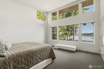 Primary suite with vaulted ceilings and floor to ceiling windows to capture the captivating lake views.