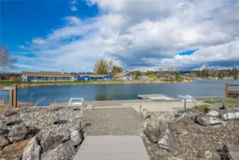 View from above the waters edge patio with professional easy maintenance landscape elements throughout.