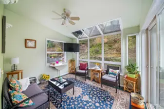 cozy sunroom facing backyard and opens to deck