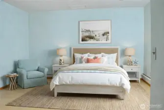 The lower-level bedroom offers a peaceful, coastal-inspired space with light flooring and a comfortable layout.