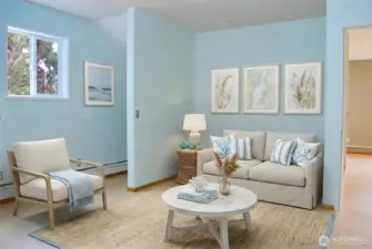 The sitting area offers a cozy, coastal-inspired space with light flooring and a comfortable spot to relax.