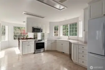 Bright & cheery kitchen offers lots of counter space & cabinetry.