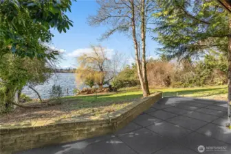 Lower-level patio with tranquil views across the lawn to the water’s edge.