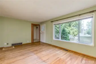 Living room at the entry has hardwood floors. Doorway leads upstairs to 2 bedrooms.