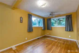 Primary bedroom on the main level has hardwood floors, walk-in closet