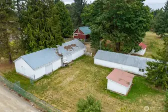 Garage/shop, barn and chicken coop. Extensive cyclone fencing keeps different portions of the property separated.