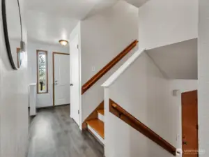 View to front door and stairs from kitchen