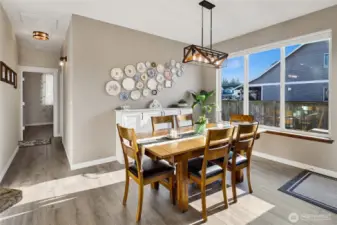 The dining area is bright and airy, offering a welcoming space for everyday meals and entertaining. A newly added built-in provides stylish storage for serving pieces and extra dishes, while also serving beautifully as a coffee or beverage bar for guests. Topped with the same Nevaska granite featured in the kitchen and thoughtfully equipped with power outlets on both sides, the space blends function, convenience, and seaside inspired elegance.