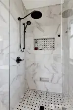 Rain shower and rain wand in this custom-tiled retreat invite luxurious, indulgent relaxation.