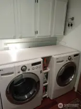 Laundry with newer appliances that stay plus storage.