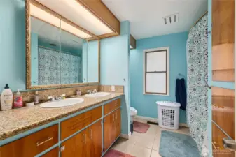 The main-floor bathroom features classic tile flooring, a full tub/shower, and a double vanity—combining timeless style with practical functionality for everyday use.