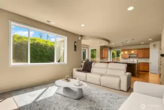 Large picture windows bring in the natural light beauty of the private backyard.