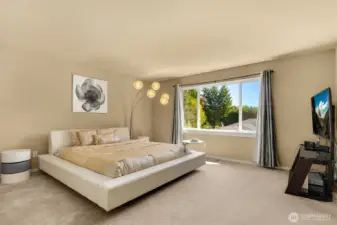 Luxurious primary bedroom with views of the backyard.