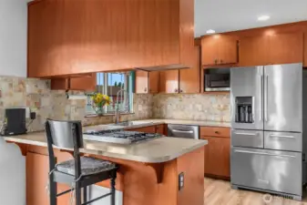 Kitchen has tall backsplash in pretty muted colors. Kitchen counter extends out for an eating bar allowing for up to three chairs. Kitchen will come with all appliances.