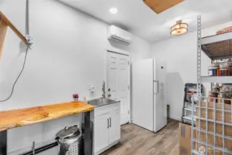 This room exits out to backyard. It is used as a mudroom and pantry for storage. Comes equipped with large sink and shelves. Attic space can be accessed from this room also.