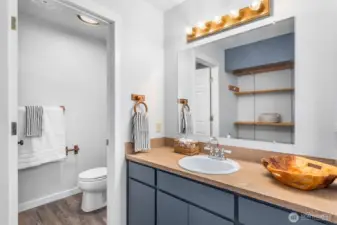 Adjoining bathroom for primary bedroom upstairs. Door closes for the toilet and shower area.