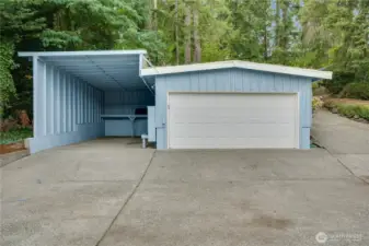 Large carport with an additional detached two-car garage offers flexibility and convenience
