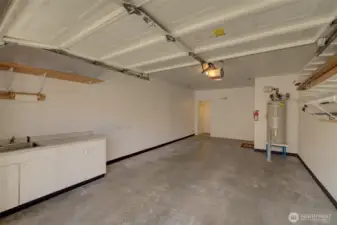 Extra large 1 car garage with storage and a convenient sink with built-in cabinetry.