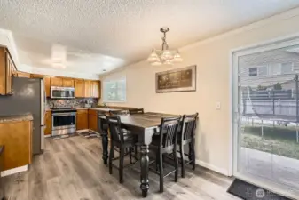 The spacious kitchen features abundant cabinet and counter space. A slider leads to the patio and backyard.