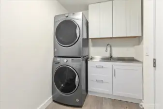 Newly remodeled laundry room with added cabinets and utility sink