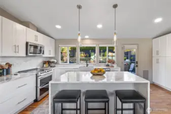 Large island with quartzite waterfall counter and eating bar