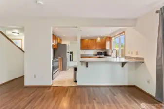 Open kitchen layout with stainless appliances, a breakfast bar, and clear sightlines into the dining area — great for hosting and casual meals.