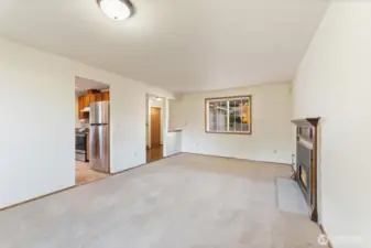 Spacious living room centered around a classic gas fireplace and large picture window. A warm and inviting space perfect for relaxing or entertaining.