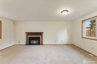 Comfortable living area highlighted by a classic gas fireplace with a wood mantel, perfect for relaxing evenings and creating an inviting focal point for the space.