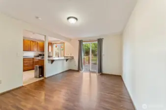 Open dining space with laminate flooring and direct access to the back deck through sliding glass doors — ideal for indoor/outdoor entertaining and gatherings.