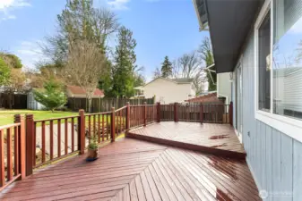 Beautifully maintained oversized deck with rich wood tones — perfect for BBQs, outdoor dining, and year-round entertaining.