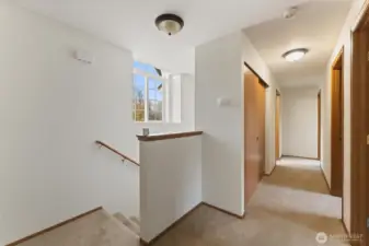 Bright upstairs landing with large window, neutral colors, and easy access to all bedrooms and the full bathroom.