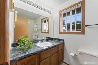 Bright full bathroom featuring a spacious vanity with large wall mirror, and ample natural light from the window. Clean, functional, and move-in ready.