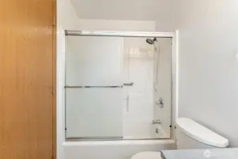 Clean and well-maintained shower/tub combination with sliding glass doors and tile surround. Practical design perfect for everyday convenience.