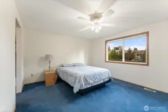 Generously sized primary bedroom with a large window overlooking the backyard, offering abundant natural light and a peaceful atmosphere.