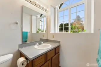 Beautifully lit bathroom with oversized picture windows, a sleek vanity, and modern lighting. The abundant natural light creates an open, refreshing feel.